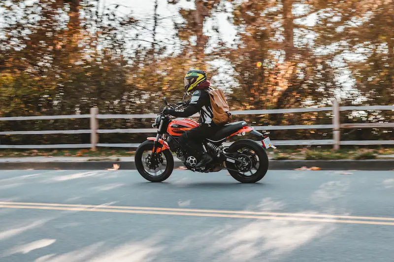 riding motorcycle with backpack