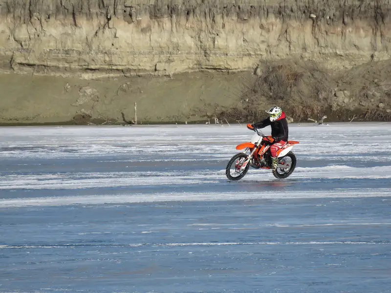 riding a motorcycle on a frozen lake