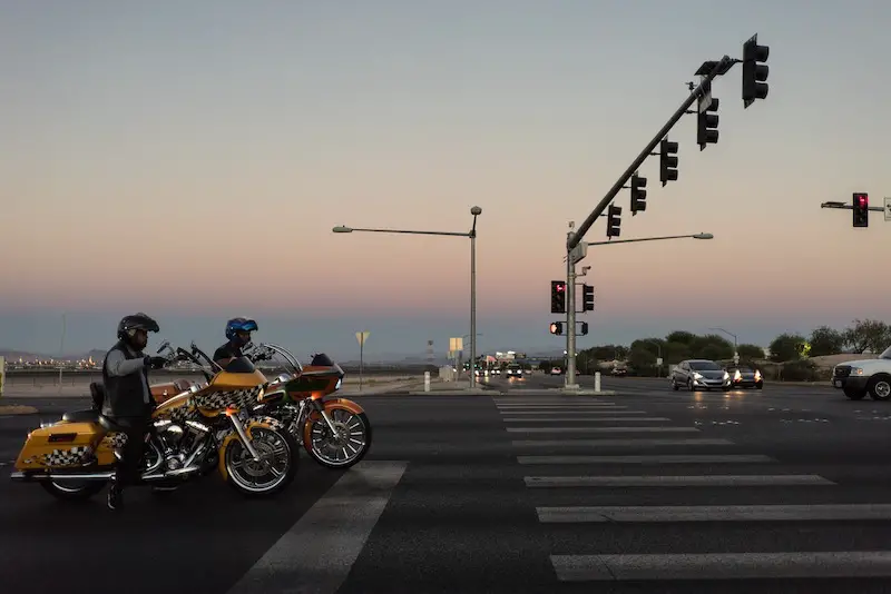 Two Harley-Davidson motorcycles waiting at a traffic light