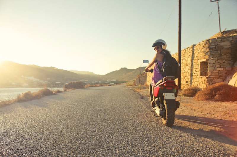 girl wearing backpack while riding motorcycle