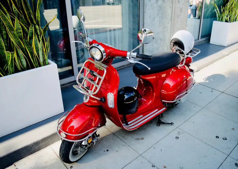 red scooter with two scooter helmets