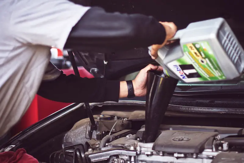 adding oil to car engine