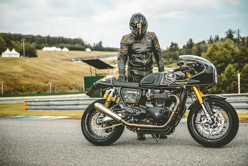 man standing above motorcycle