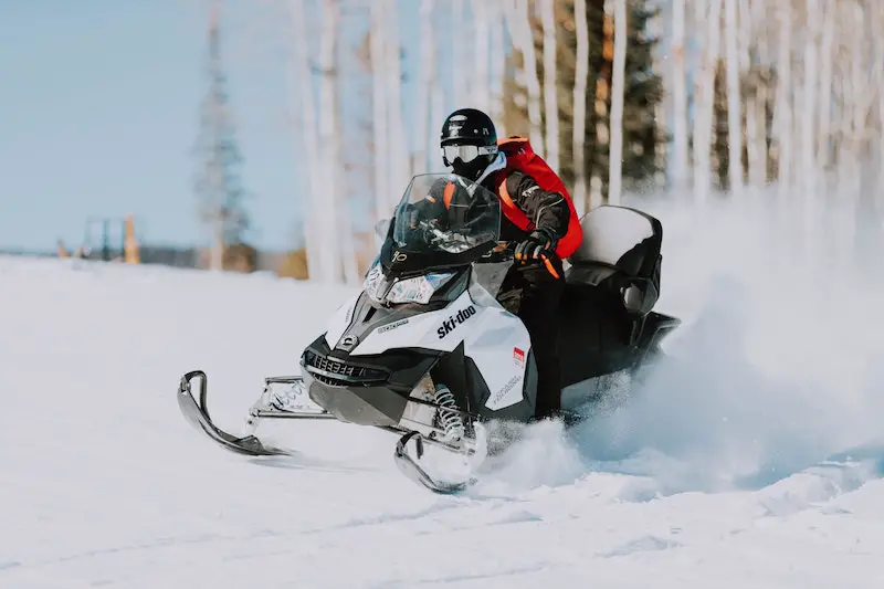 riding snowmobile through trails