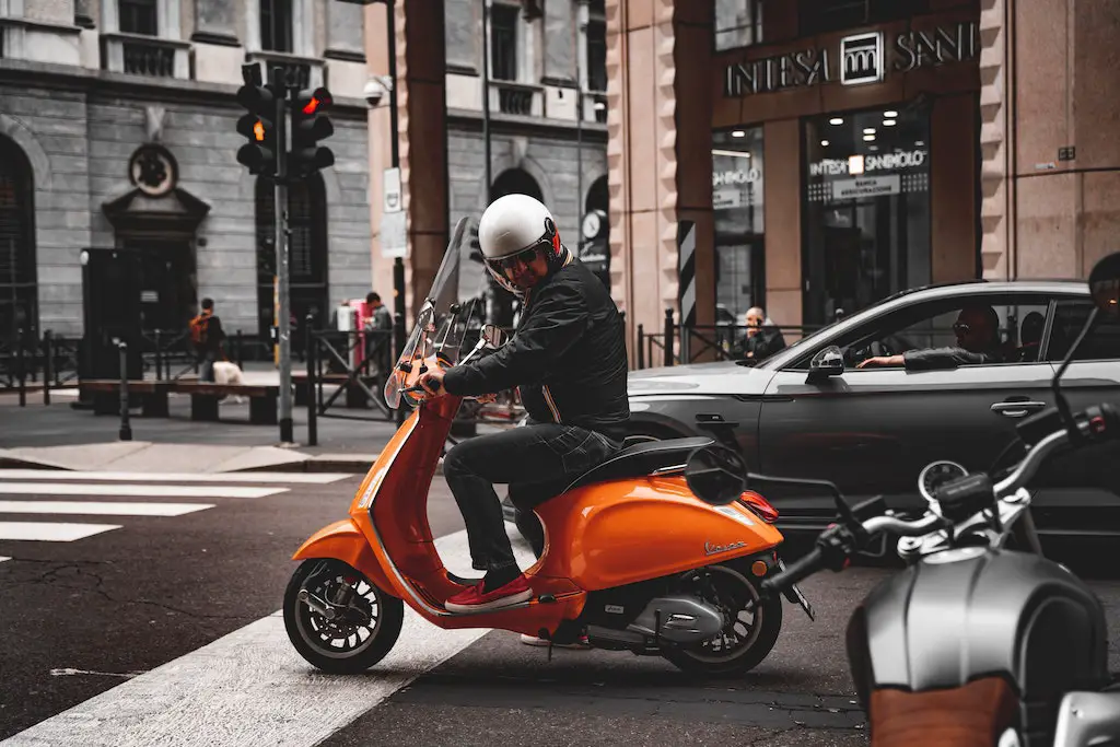 orange scooter in traffic